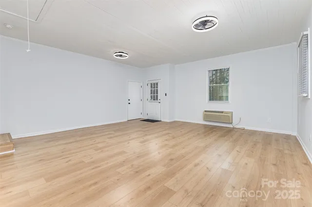 a view of empty room with wooden floor