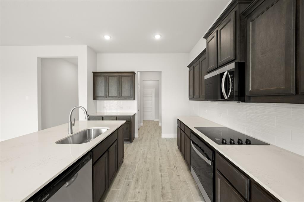 228 Shepards Street Godley, TX 76044 - Photo 5 of 27 a kitchen with stainless steel appliances a sink stove and cabinets