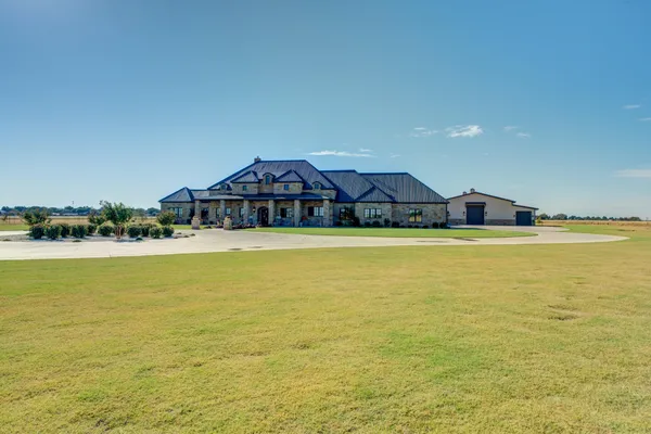 a large kitchen with granite countertop a stove a sink a dining table and chairs