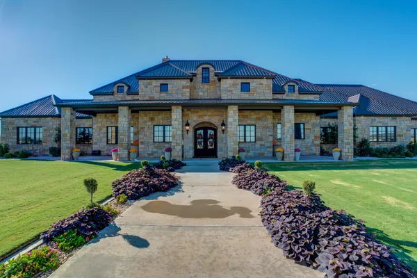 a front view of a house with a garden and plants
