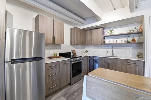 a kitchen with a refrigerator sink and cabinets