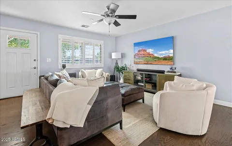 a living room with furniture a flat screen tv and a window