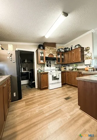 a kitchen with cabinets and wooden floor
