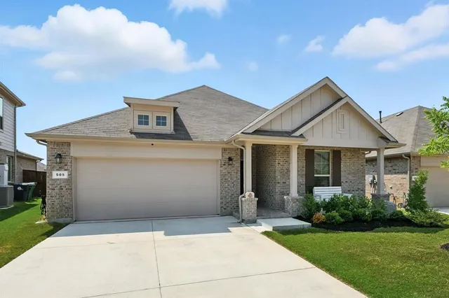 a front view of a house with a garden and yard