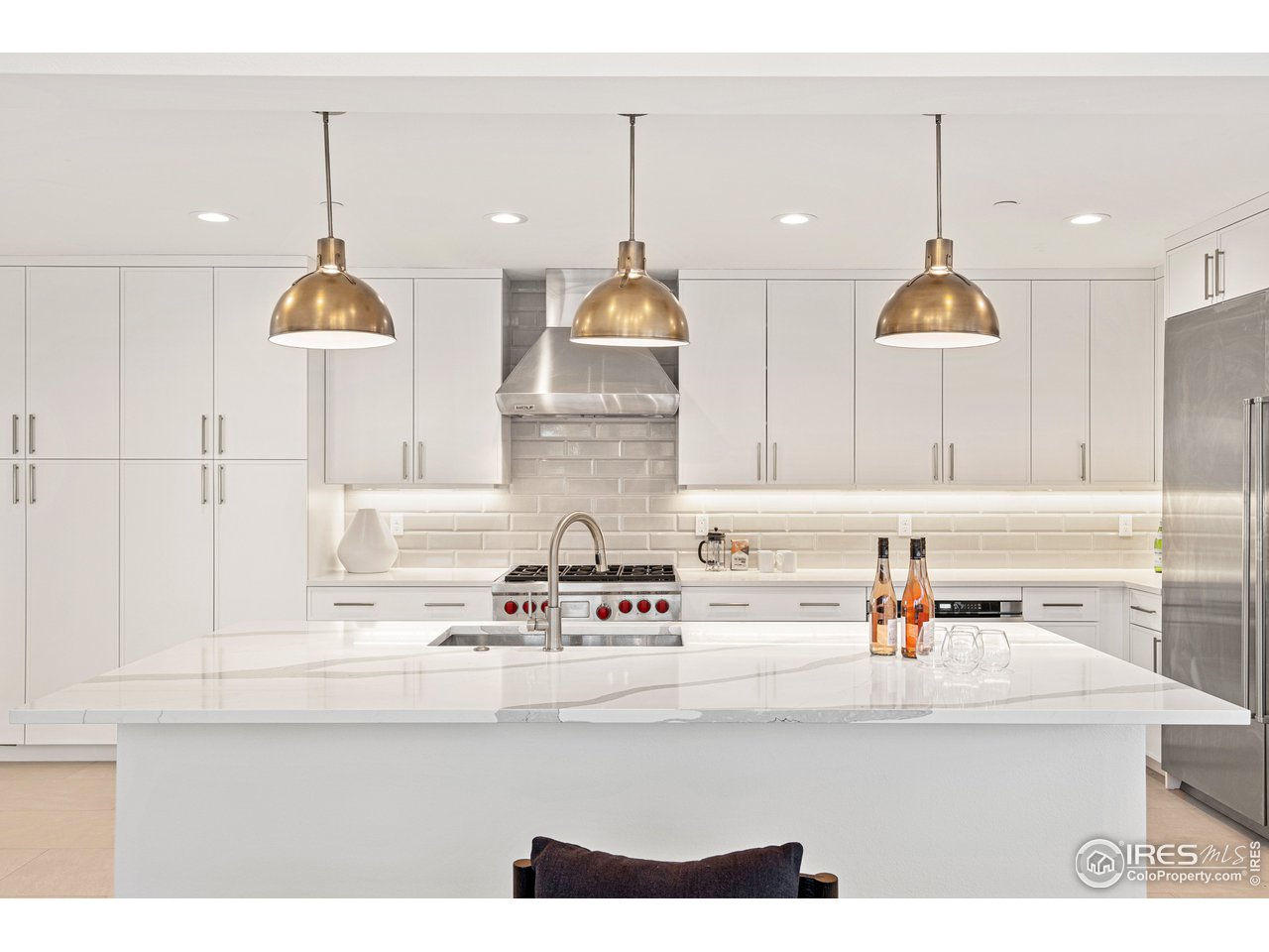 4872 Sugarloaf Road Boulder, CO 80302 - Photo 15 of 40 a kitchen with kitchen island white cabinets and a chandelier