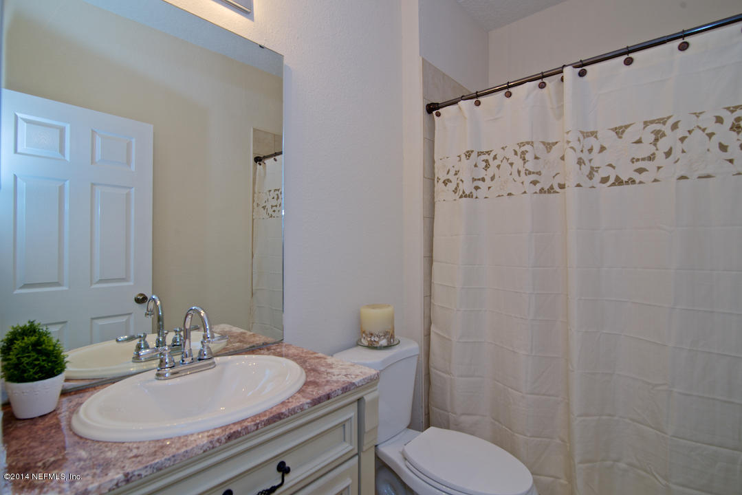 7170 Rampart Ridge Circle West Jacksonville, FL 32244 - Photo 13 of 22 a bathroom with a granite countertop sink toilet a mirror and shower curtain