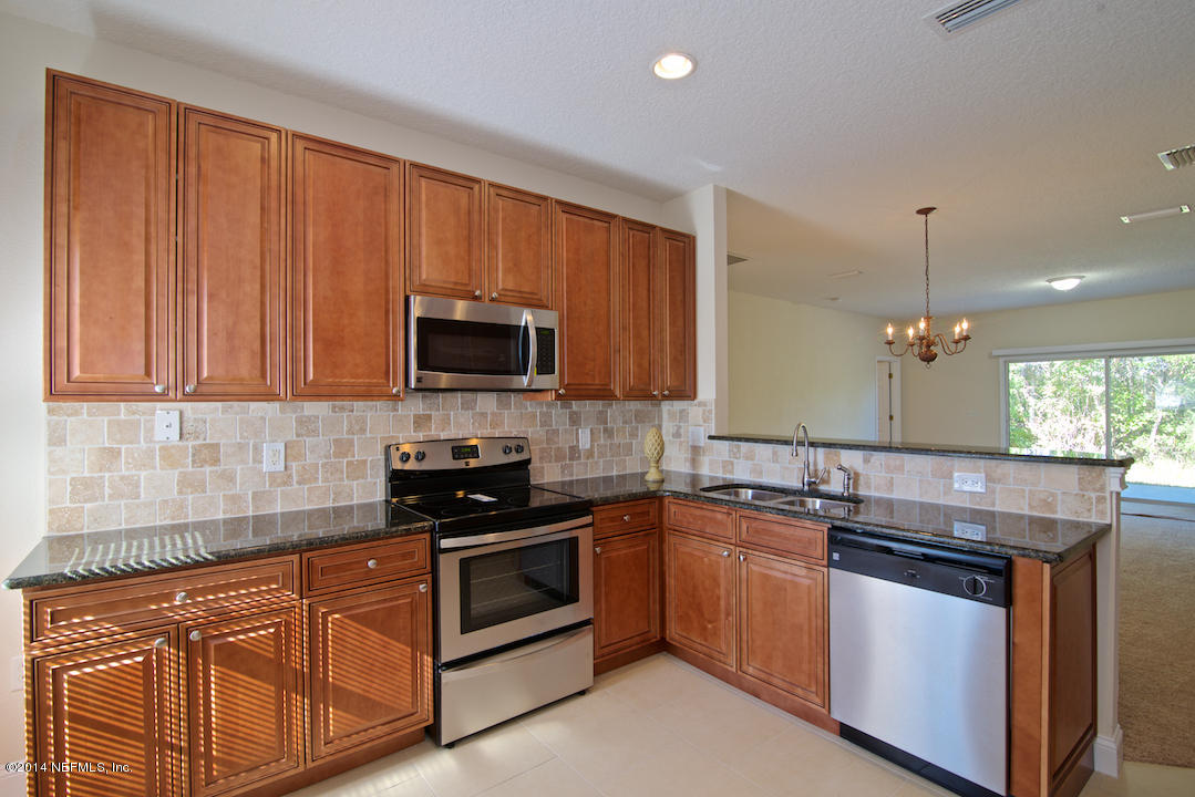 7170 Rampart Ridge Circle West Jacksonville, FL 32244 - Photo 7 of 22 a kitchen with stainless steel appliances granite countertop a sink stove and microwave