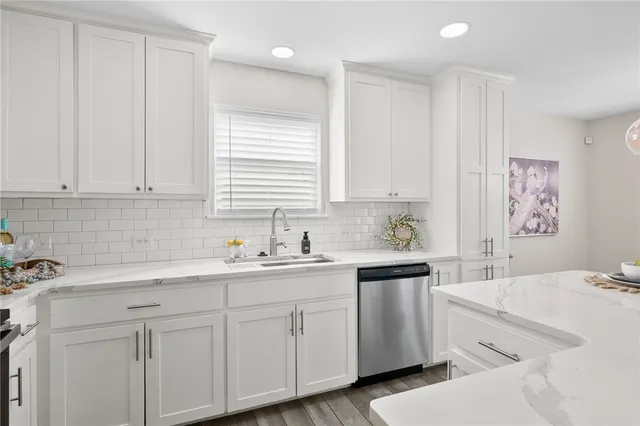 a kitchen with cabinets appliances a sink and a window