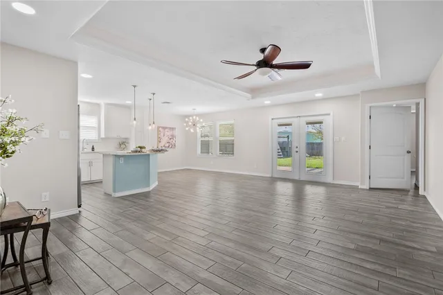 a view of an empty room with window and wooden floor
