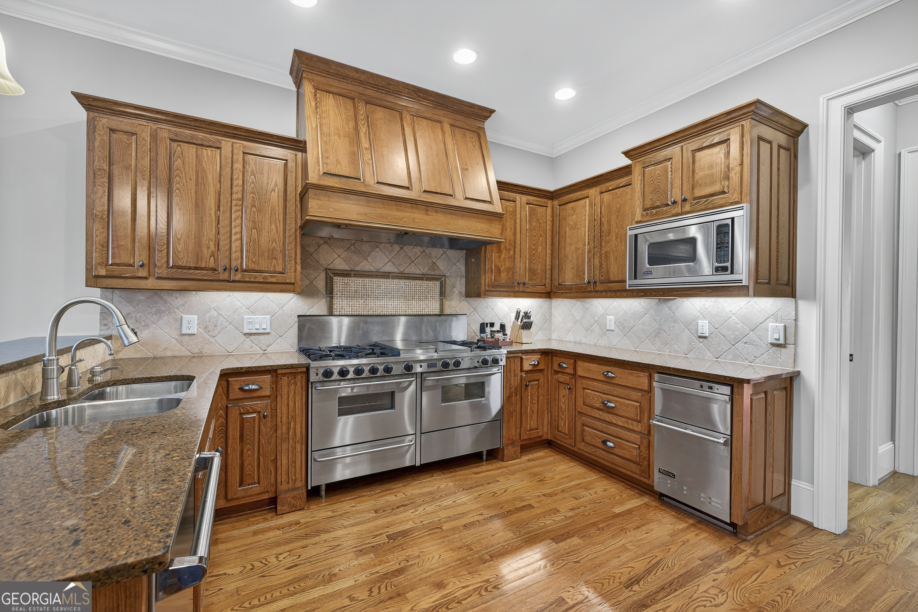 675 Garden Circle Statham, GA 30666 - Photo 28 of 98 a kitchen with stainless steel appliances granite countertop a stove top oven a sink dishwasher and cabinets with wooden floor