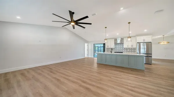 a view of a livingroom with wooden floor and a ceiling fan