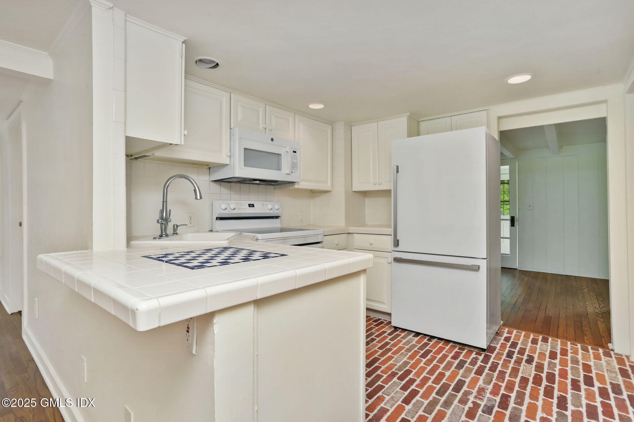27 Seeley Road Wilton, CT 06897 - Photo 11 of 27 a kitchen with a sink a stove a refrigerator and white cabinets