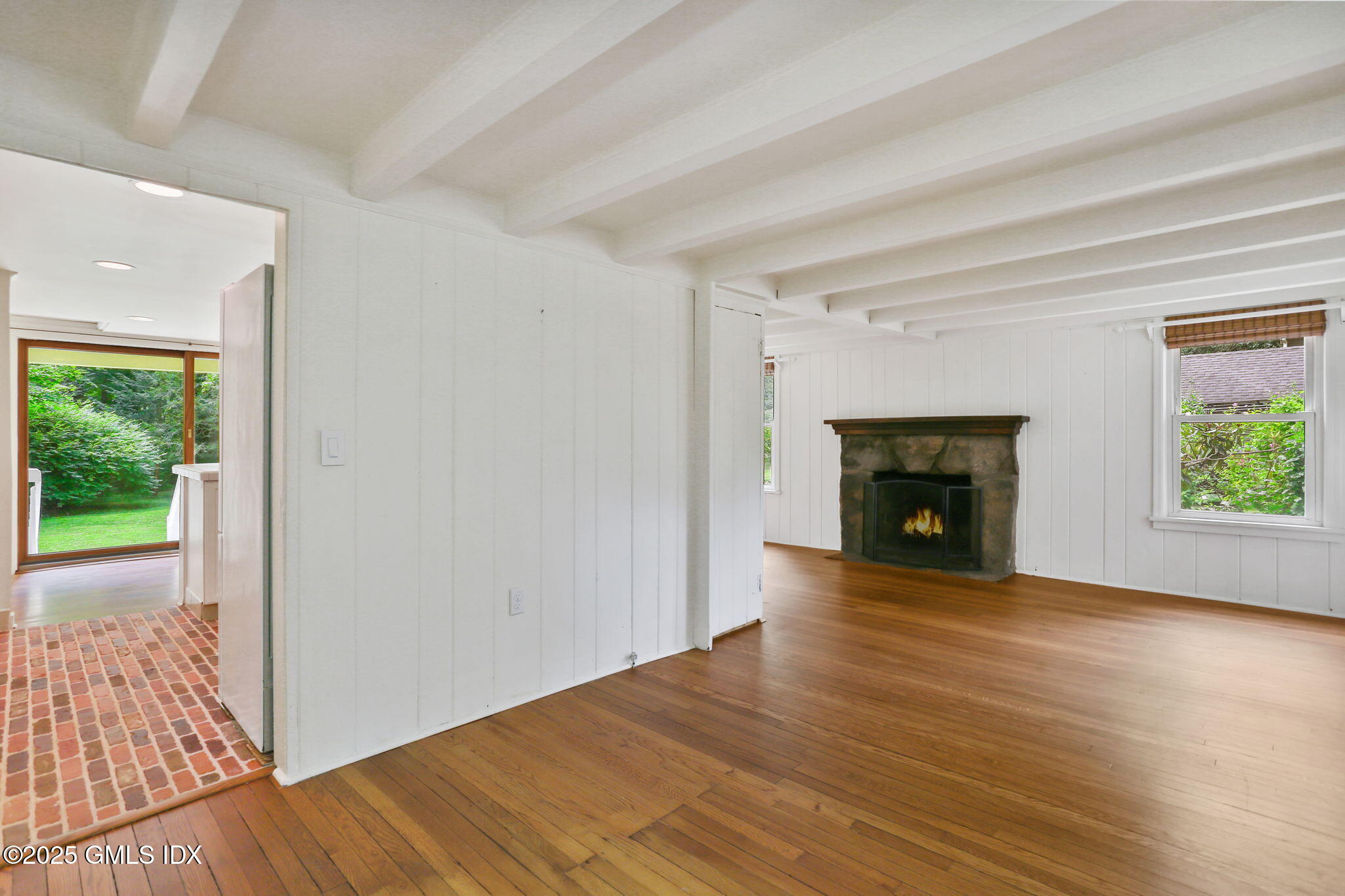 27 Seeley Road Wilton, CT 06897 - Photo 2 of 27 a view of empty room with wooden floor and fireplace