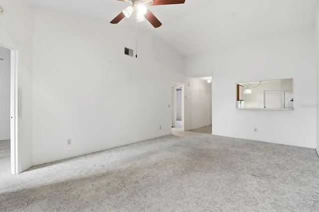 an empty room with a ceiling fan and a window