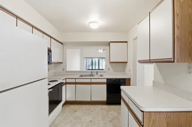 a kitchen with a sink a stove a refrigerator and cabinets