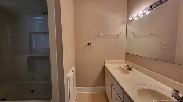 a bathroom with a sink and mirror with shower
