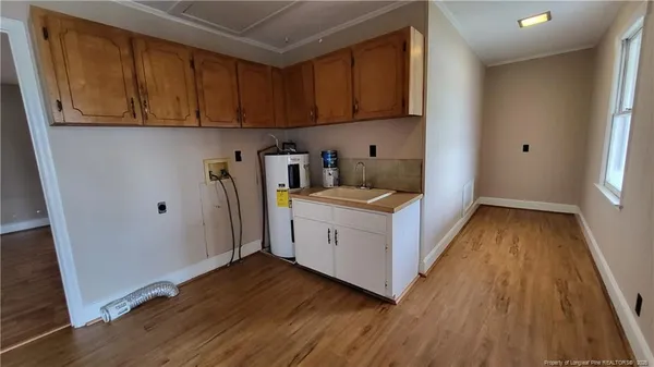 a utility room with wooden floor washer and dryer