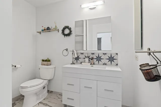 a bathroom with a sink toilet and mirror