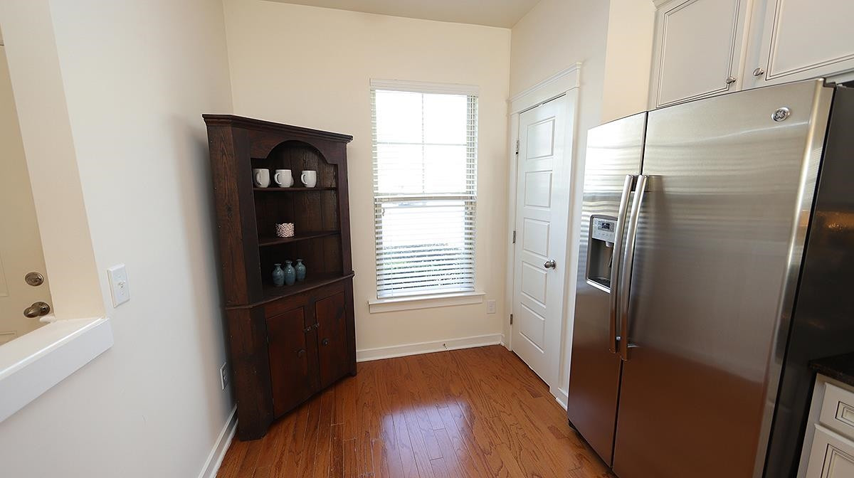 6414 Swatner Drive Raleigh, NC 27612 - Photo 3 of 21 Beautiful Hardwood Laminate throughout the Main Floor makes for ease of cleaning and consistency throughout. View of Kitchen