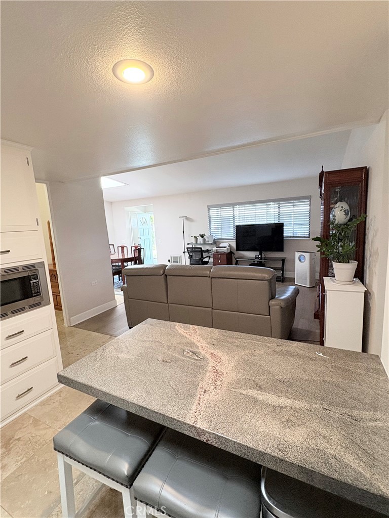 1680 Monterey Road Seal Beach, CA 90740 - Photo 13 of 19 a living room with stainless steel appliances kitchen island granite countertop furniture and a kitchen view