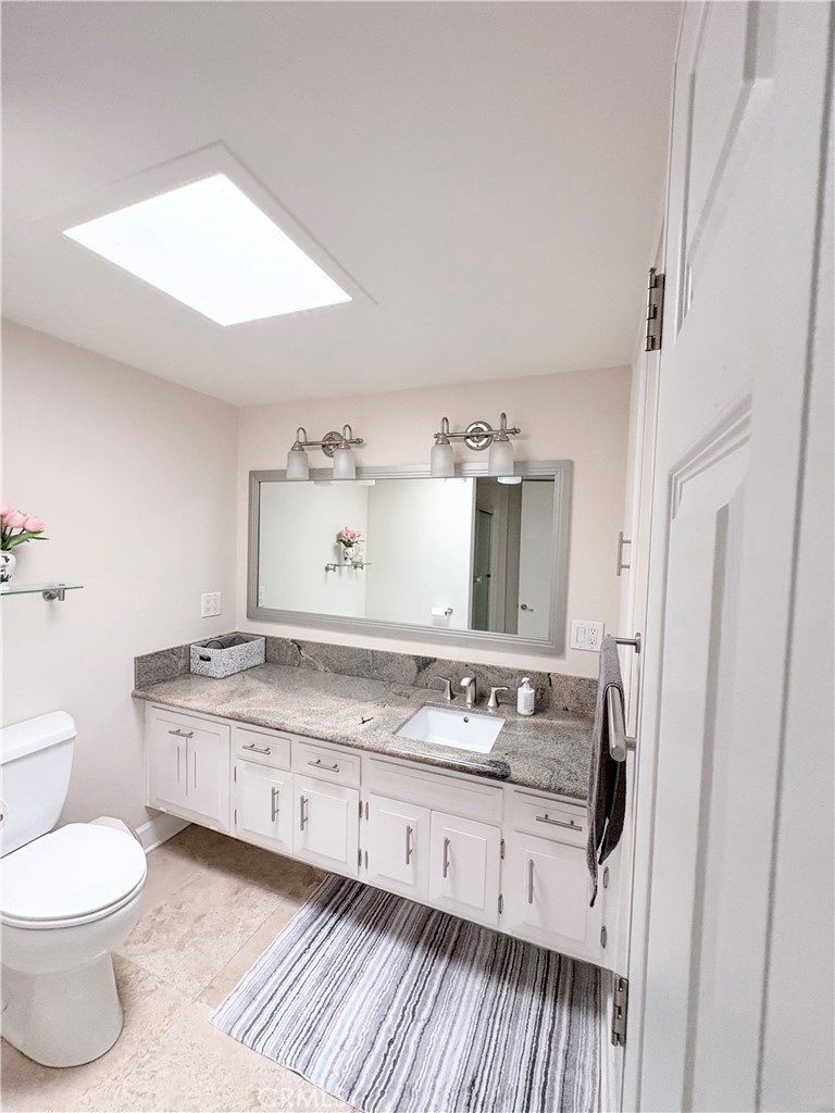 1680 Monterey Road Seal Beach, CA 90740 - Photo 15 of 19 a bathroom with a granite countertop sink toilet and mirror