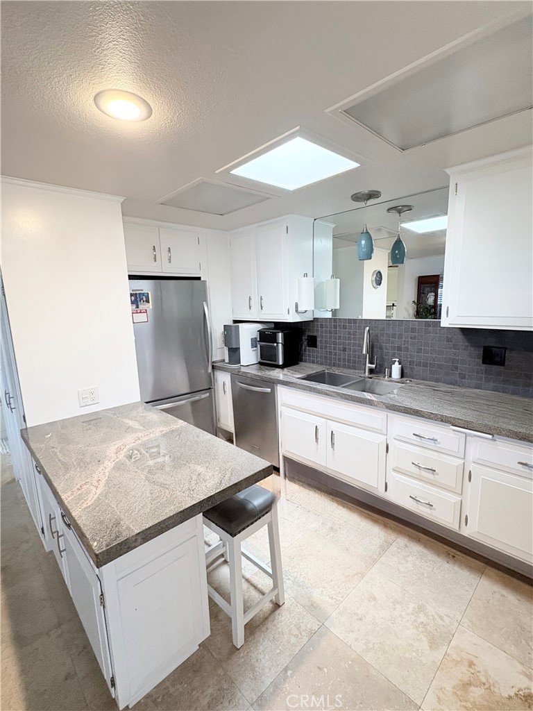 1680 Monterey Road Seal Beach, CA 90740 - Photo 10 of 19 a kitchen with granite countertop white cabinets and refrigerator