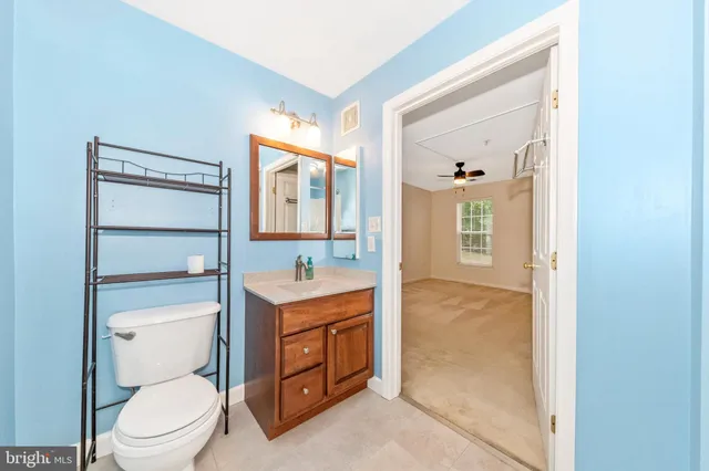 a spacious bathroom with a toilet sink and mirror