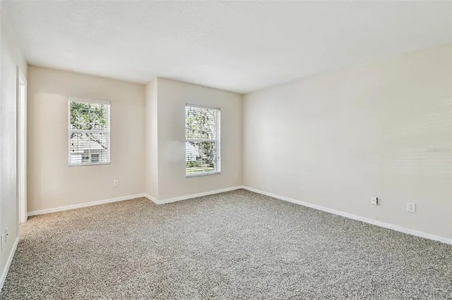 a view of an empty room with closet and a window