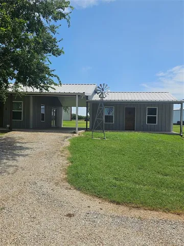 a view of a house with a yard and sitting area