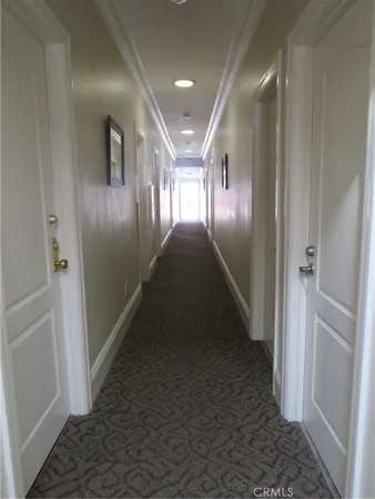 a view of an empty room with wooden floor and closet