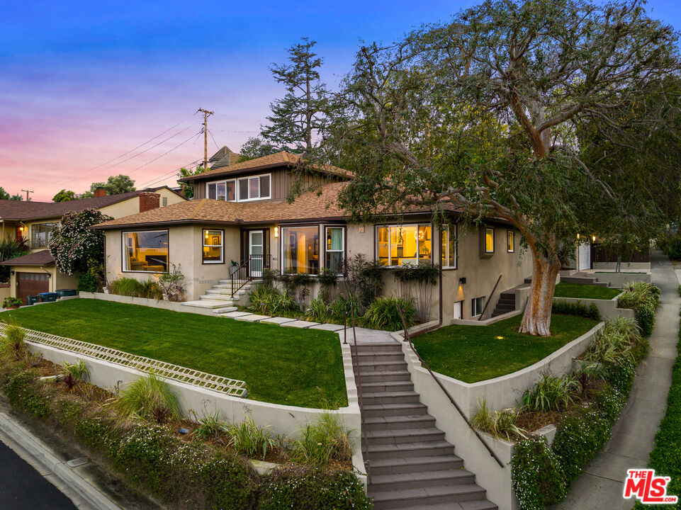 a view of a house with backyard and sitting area