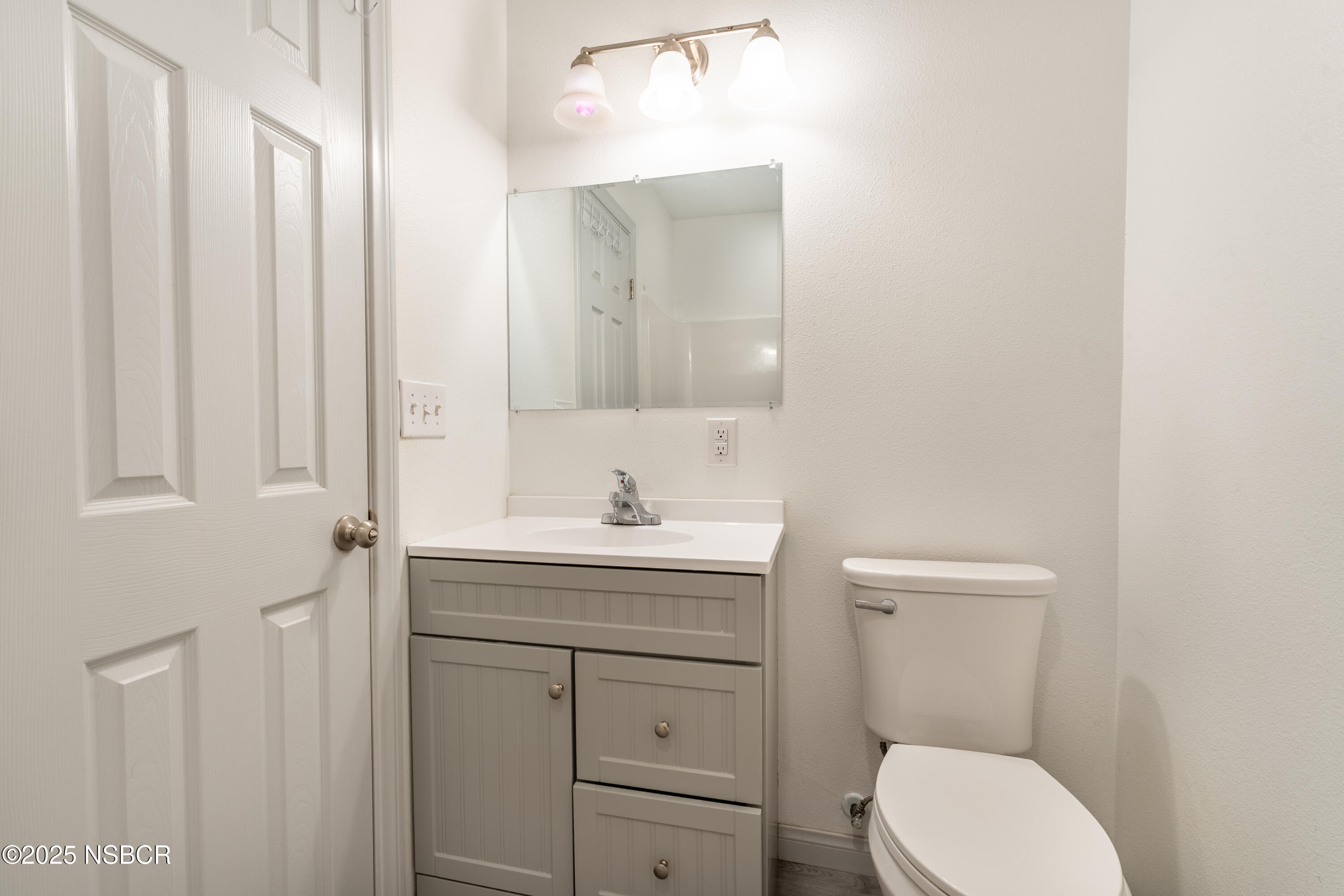 4564 South Bradley Road Santa Maria, CA 93455 - Photo 12 of 16 a bathroom with a toilet a sink a vanity and mirror