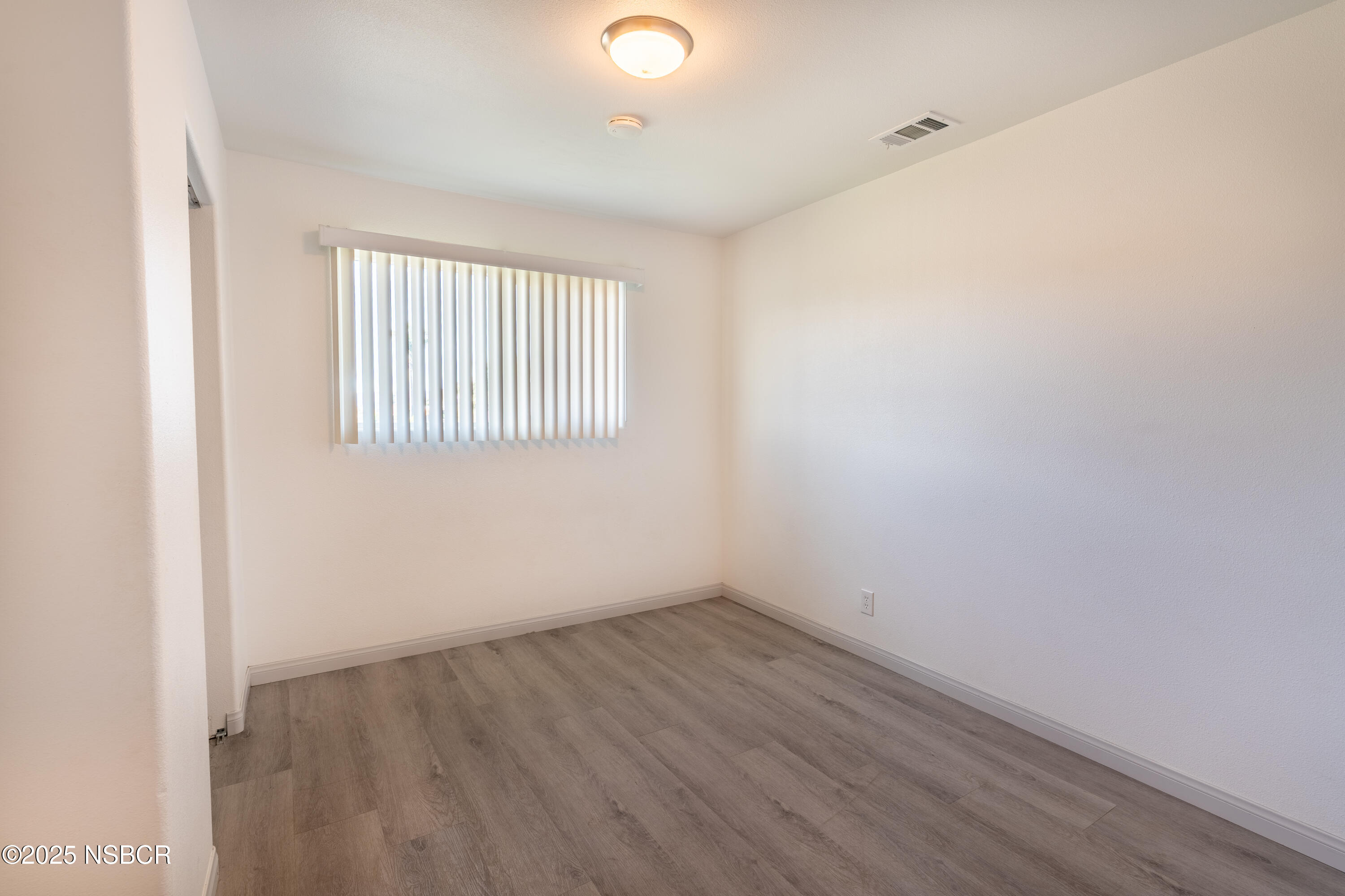 4564 South Bradley Road Santa Maria, CA 93455 - Photo 6 of 16 an empty room with wooden floor and windows