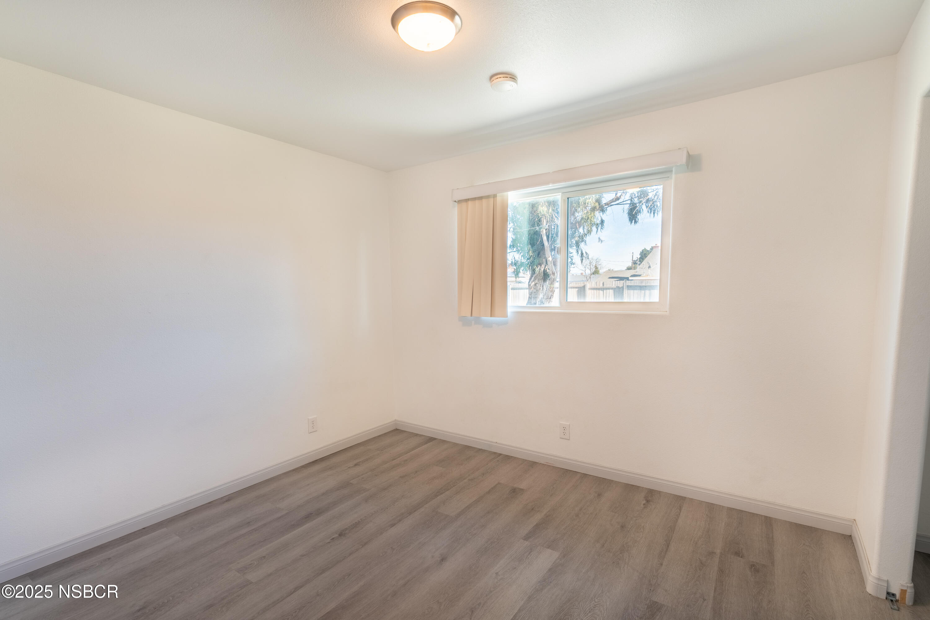 4564 South Bradley Road Santa Maria, CA 93455 - Photo 7 of 16 an empty room with wooden floor and windows