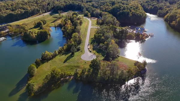 an aerial view of a house with a yard and lake view