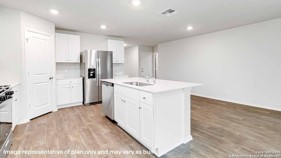 14731 Clay Rdg Run San Antonio, TX 78253 - Photo 11 of 55 a kitchen with a sink stainless steel appliances and white cabinets