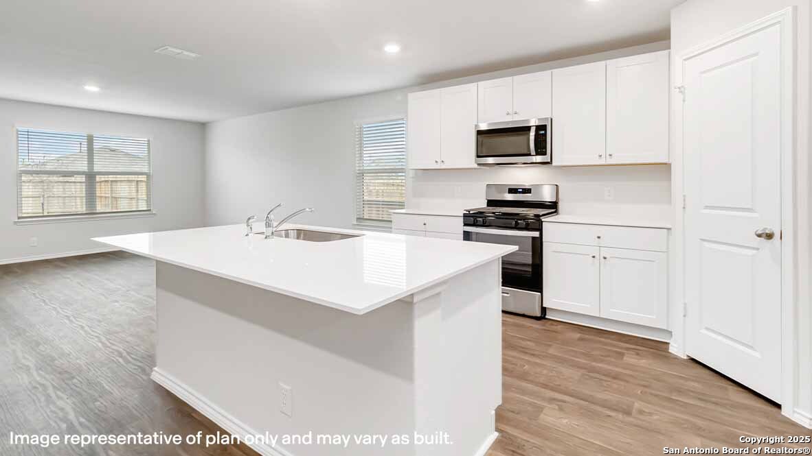 14731 Clay Rdg Run San Antonio, TX 78253 - Photo 4 of 55 a kitchen with a sink a stove and microwave