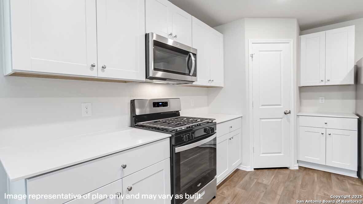 14731 Clay Rdg Run San Antonio, TX 78253 - Photo 7 of 55 a kitchen with stainless steel appliances granite countertop white cabinets and a stove top oven