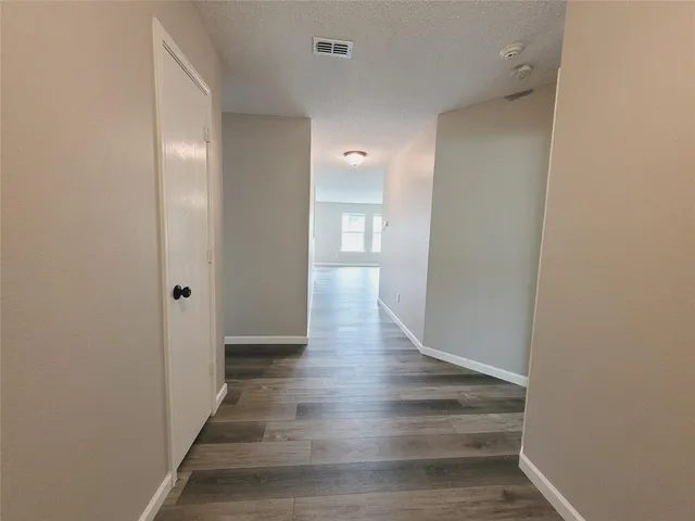a view of a hallway with wooden floor