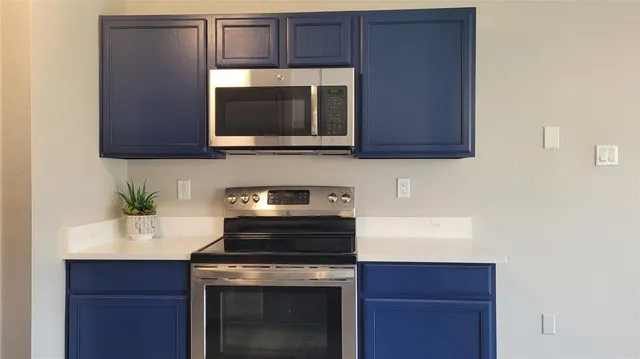 a kitchen with a sink stove top oven and cabinets