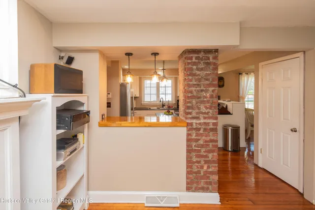a view of a hallway with wooden floor and windows