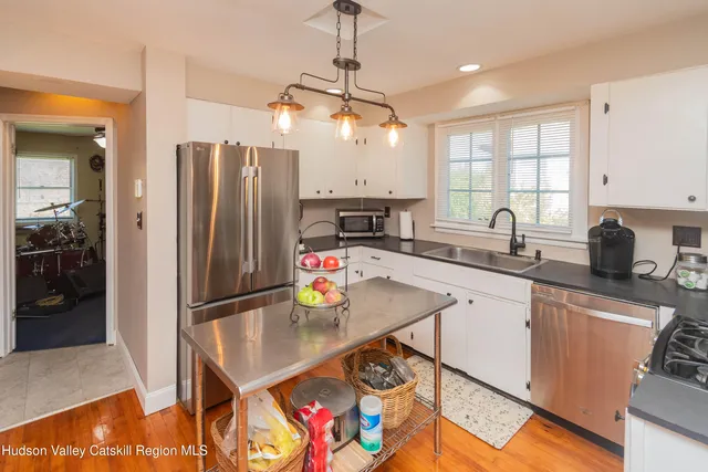 a kitchen with stainless steel appliances granite countertop a sink refrigerator and cabinets