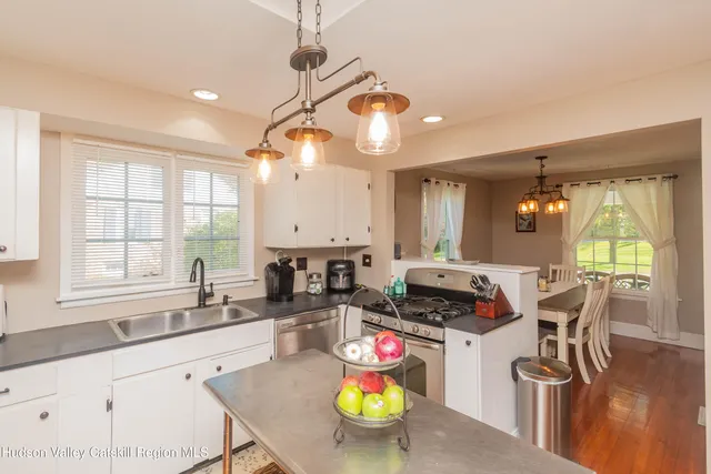 a kitchen with stainless steel appliances kitchen island granite countertop a stove a sink and a granite counter tops with white cabinets