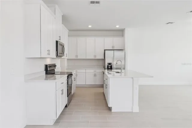 a kitchen with white cabinets and white appliances