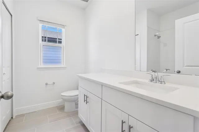 a bathroom with a granite countertop sink toilet and mirror
