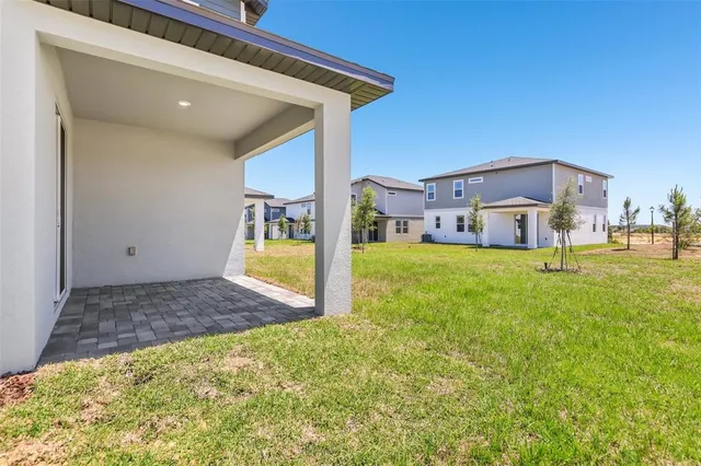 a view of a house with a big yard and large tree