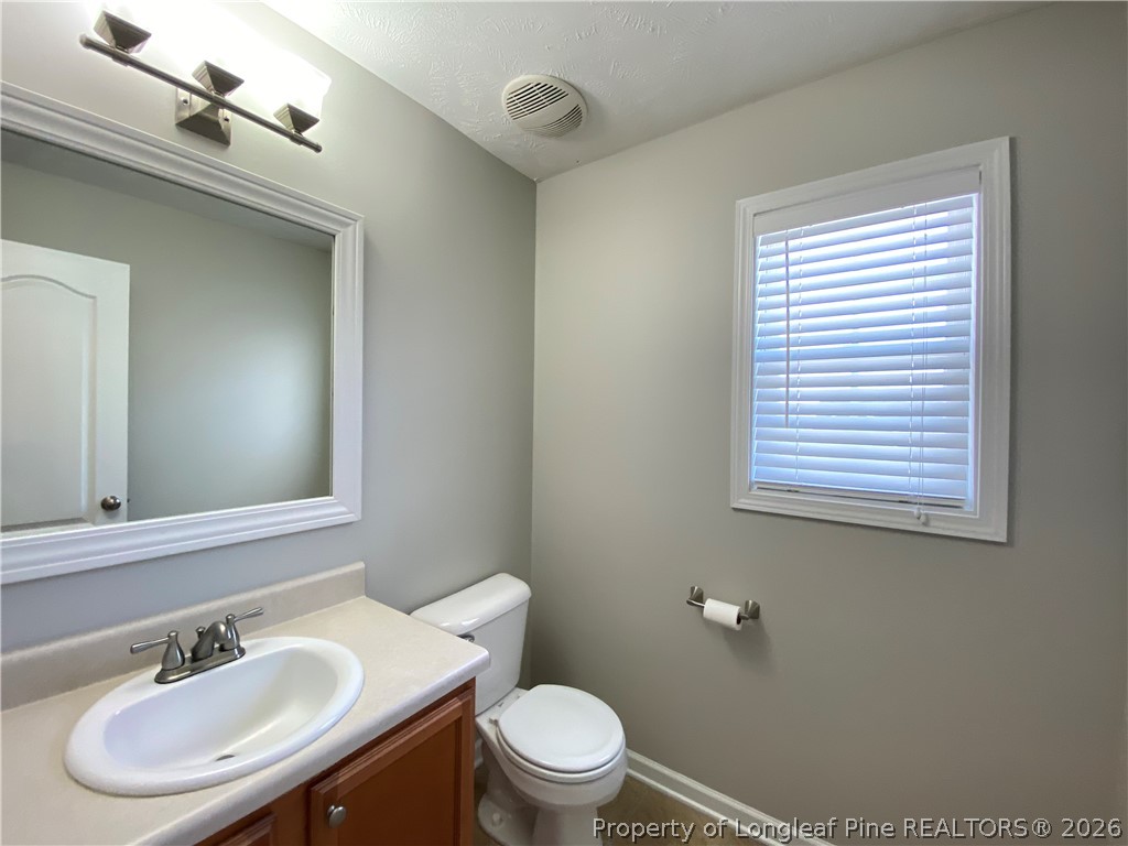 58 Polk Street Spring Lake, NC 28390 - Photo 17 of 26 a bathroom with a sink toilet a mirror and a window
