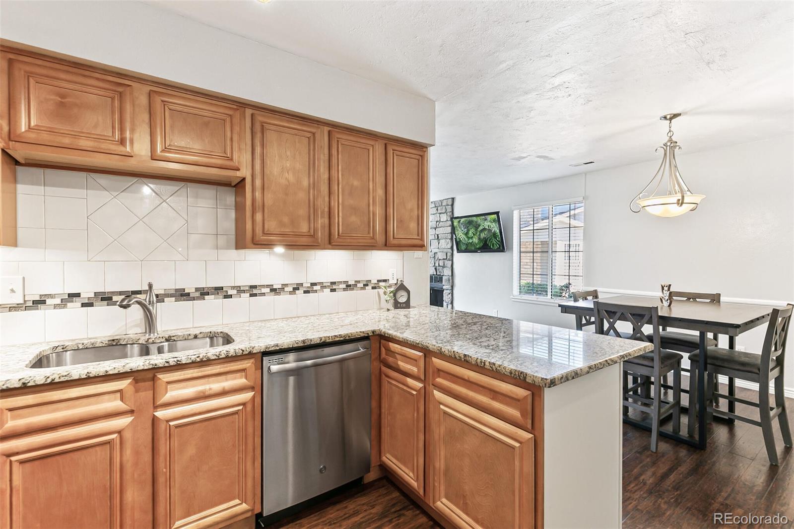 8417 Everett Way, Unit C Arvada, CO 80005 - Photo 19 of 34 a kitchen with stainless steel appliances granite countertop a sink stove and cabinets