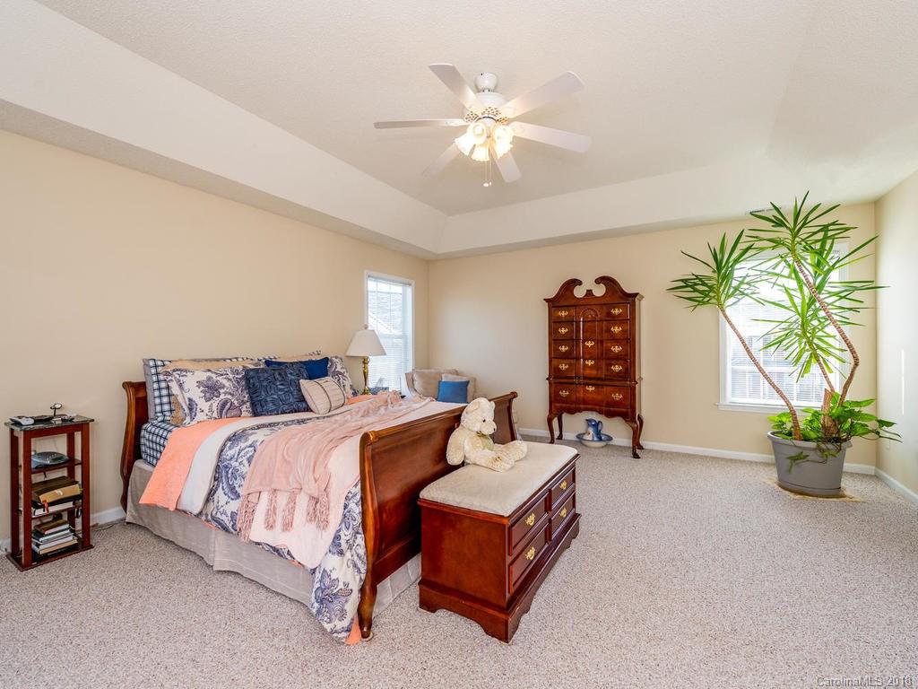 63 Woodfern Road Fletcher, NC 28732 - Photo 14 of 29 a bedroom with a bed and a chandelier