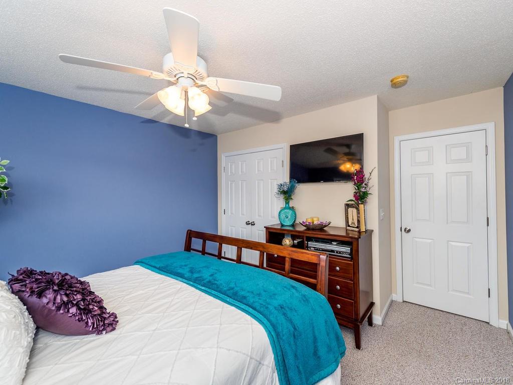 63 Woodfern Road Fletcher, NC 28732 - Photo 22 of 29 a bedroom with a bed and a flat tv screen on the dresser